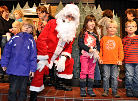 Der Weihnachtsmann mit
					Kindern und Müttern in Coesfeld auf der Bühne.