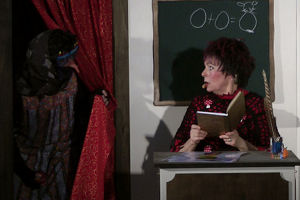 Während Hexe Schmusemund in einem Buch liest, schleicht sich die böse Moorhexe ins Klassenzimmer der Hexenschule.