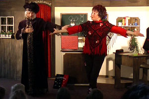 Zauberlehrer und Hexe Schmusemund freuen sich mit den Kindern im Publikum.