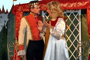 Der Prinz, also der ehemalige Frosch, steht mit Prinzessin Herzegunde zusammen, die ihre goldene Kugel in der Hand hält.